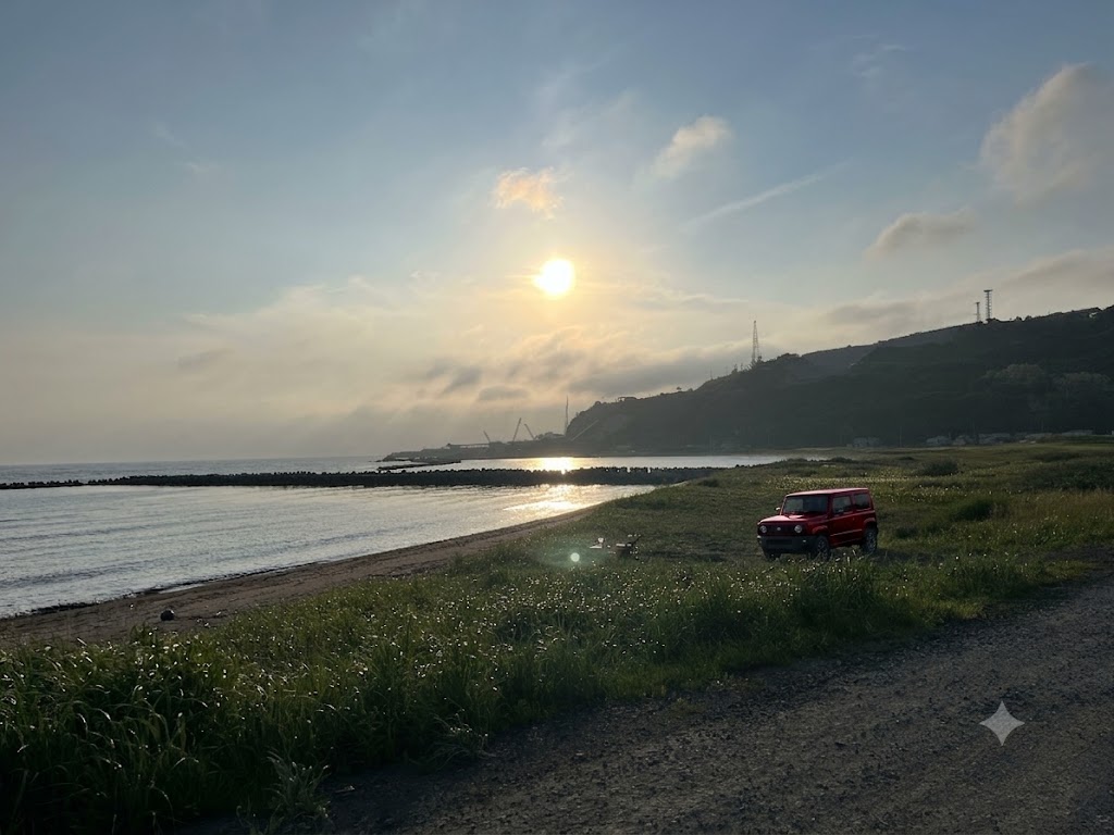 夕陽と泊村の海岸に停めた赤いジムニー