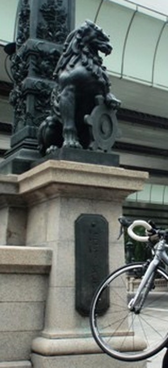 日本橋の親柱と獅子像、ロードバイクの前輪