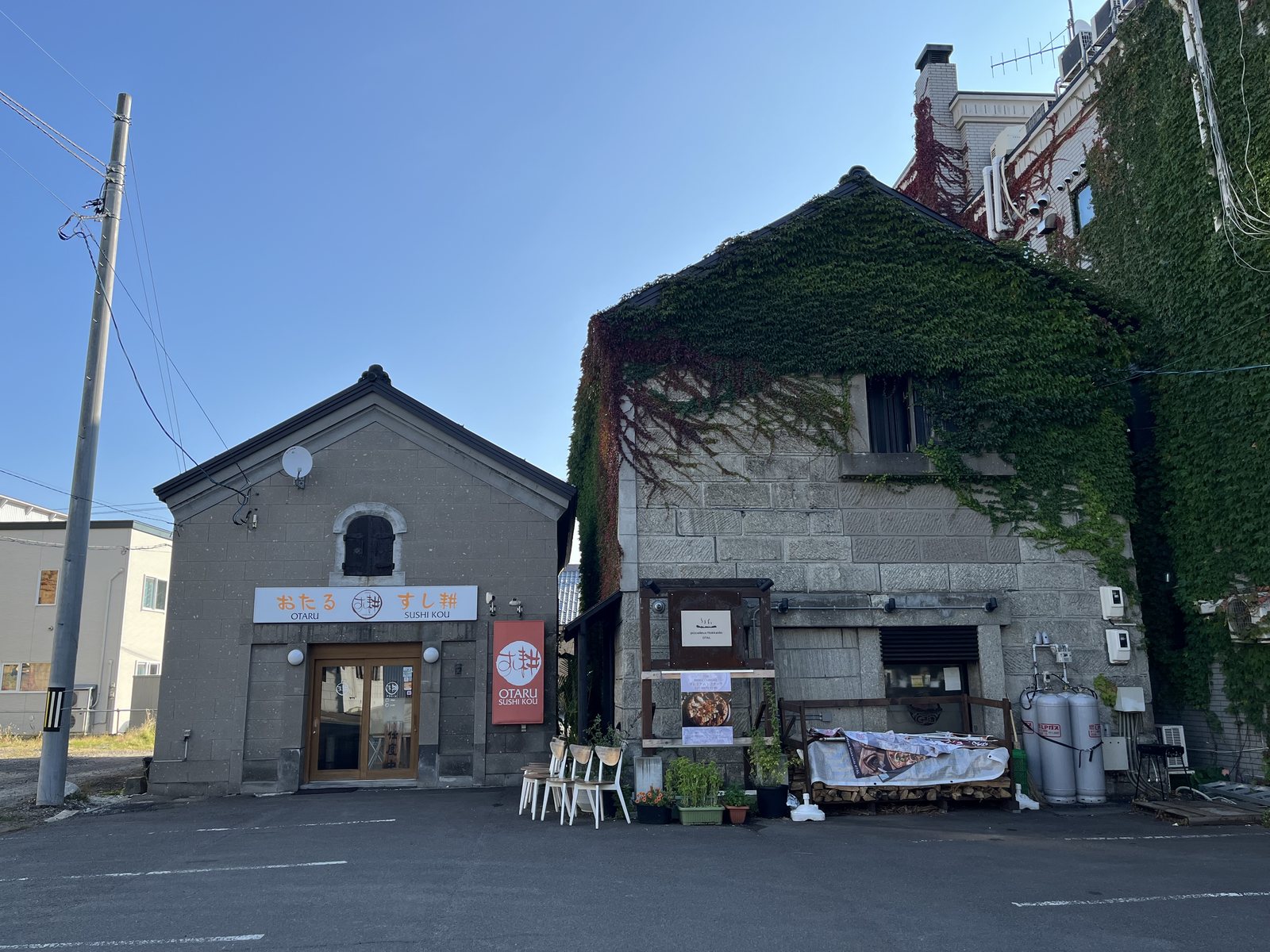ツタのからまる石の倉庫と、石の建物のすし店